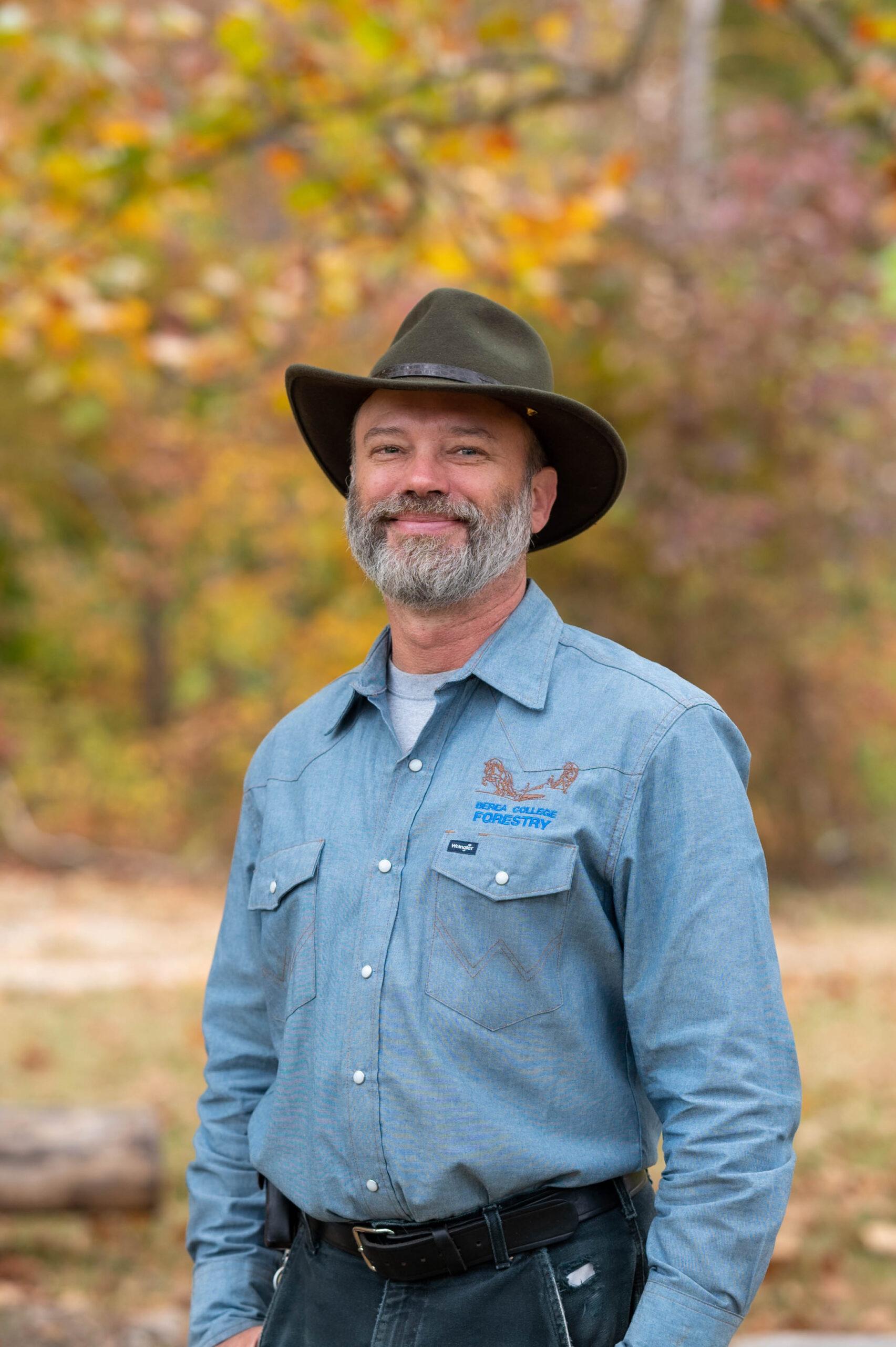 A man poses for the camera, smiling.