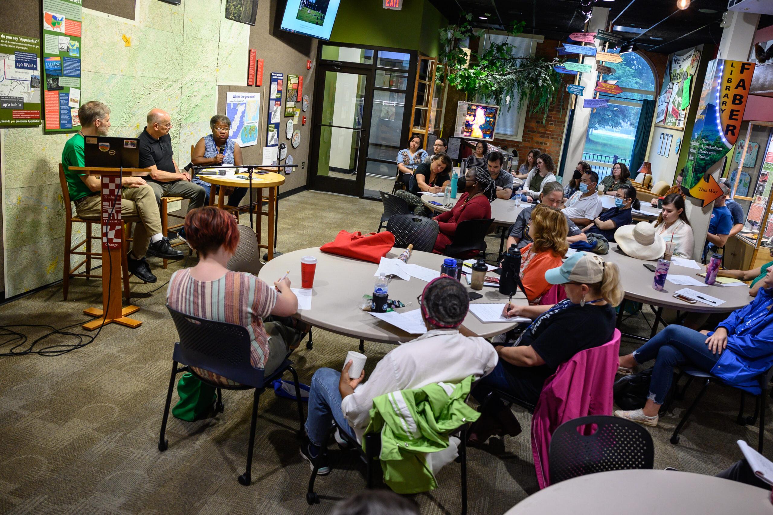 A group discussion with a large audience led by two moderators in the main area of the Loyal Jones Appalachian Center.